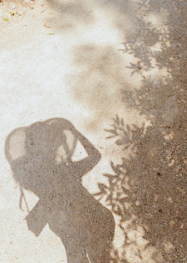 photo d'un sol sablonneux sur lequel apparait l'ombre d'une femme en train de prendre une photo